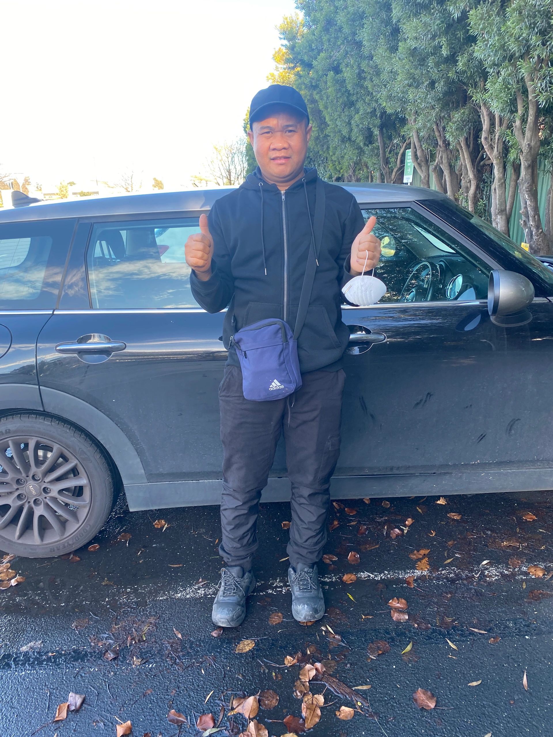 Student thumbs up outside car